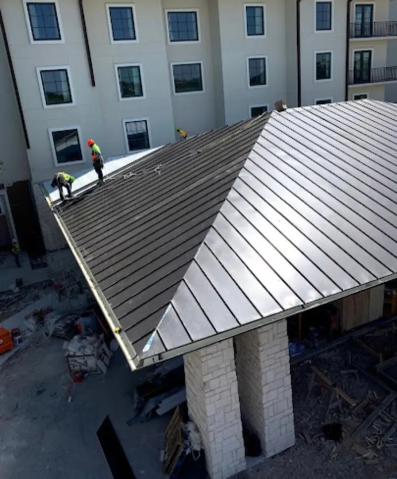 Crew installing standing seam metal roof panels on a commercial project in Citrus Hills